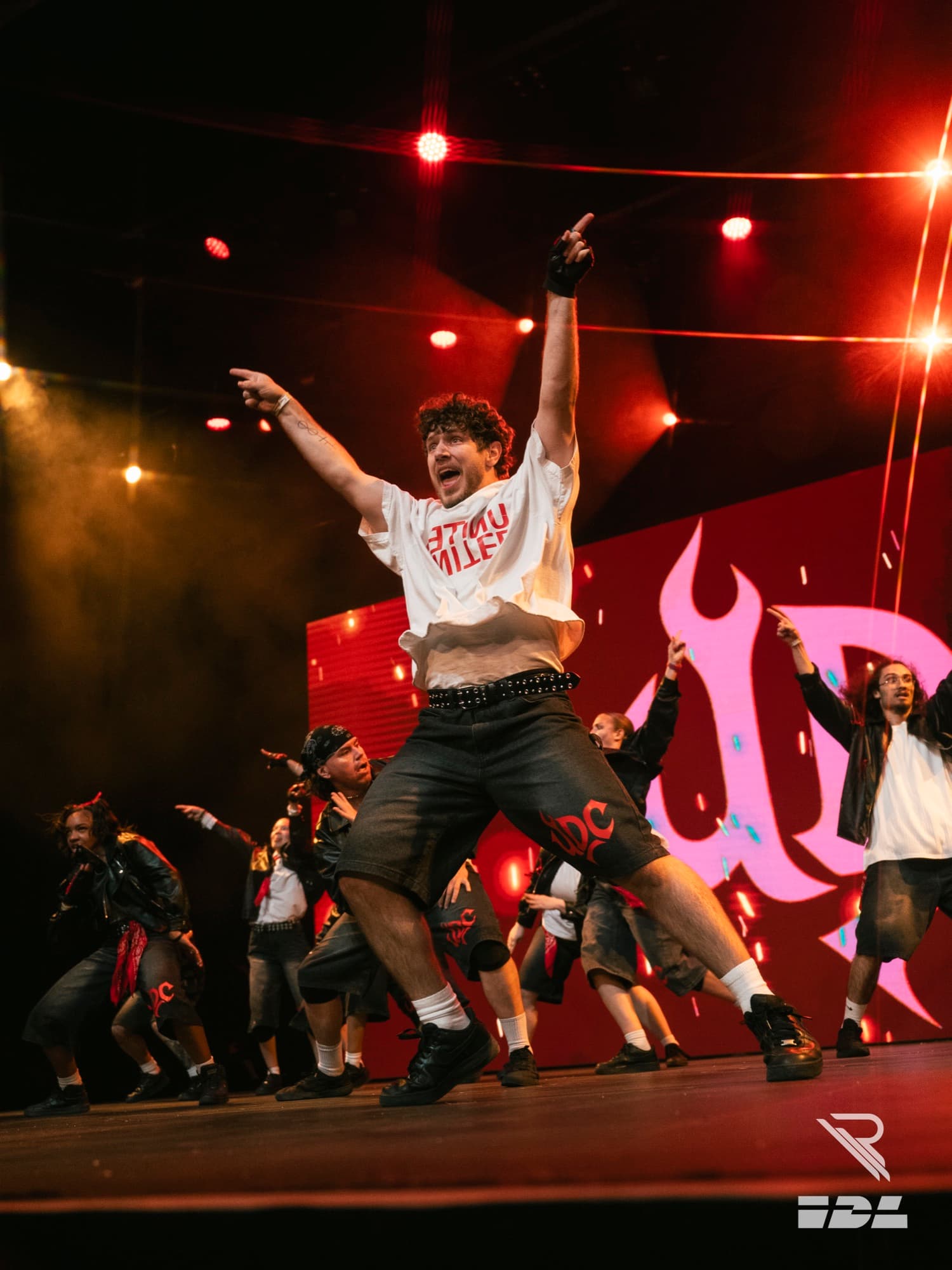 Resurgence dancer with arms raised on stage